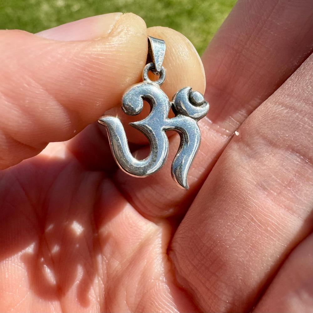 Modern Om Symbol Sterling Silver Pendant in hand