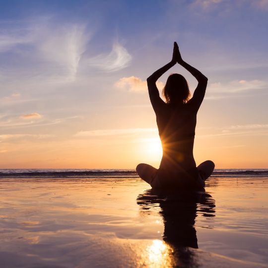 Yogi meditating at the sea on an odyssey with the odyssey yoga strap