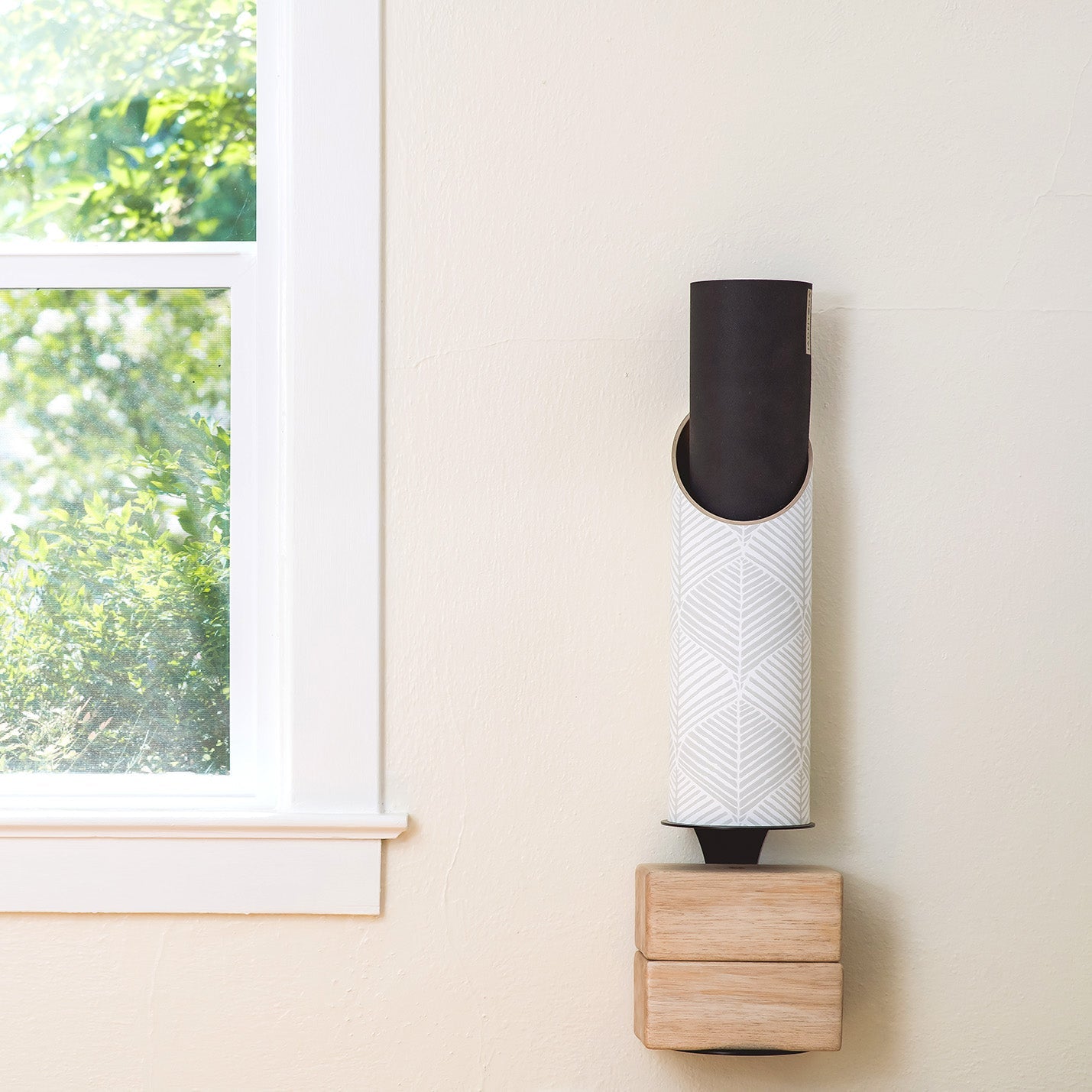 Leaf Out Yoga Mat Tube on a wall holding yoga mat and yoga blocks