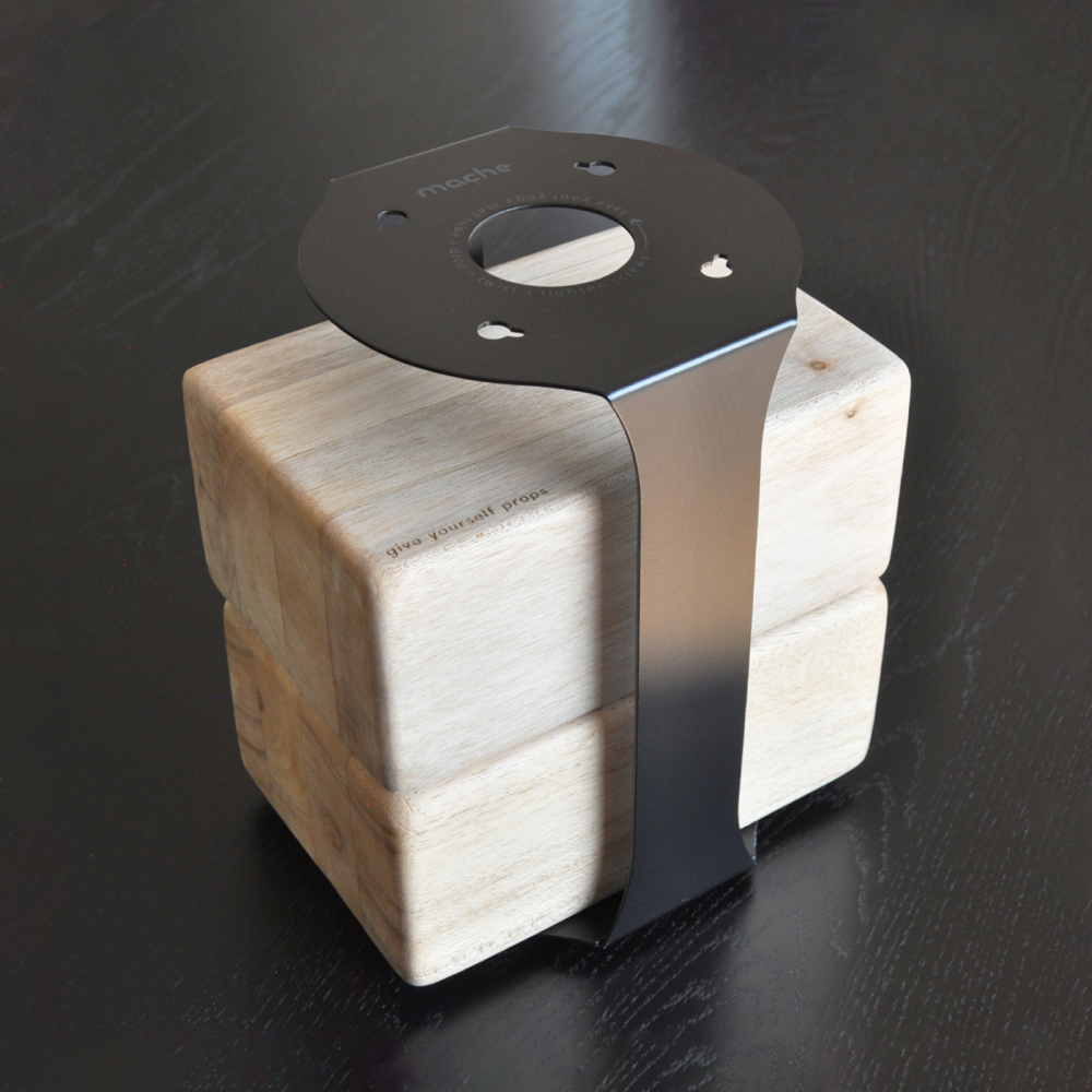 Black Homi yoga block floor stand displayed with yoga props