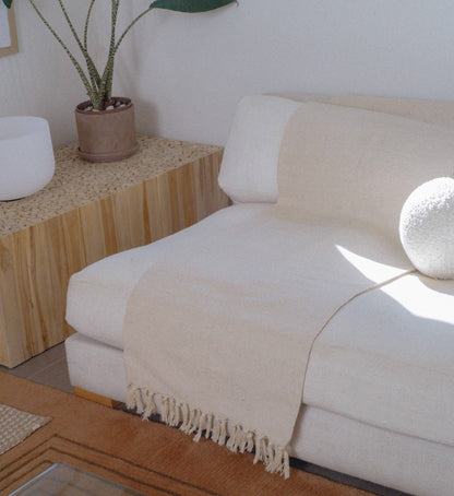 Cream organic cotton yoga blanket in a home yoga setting